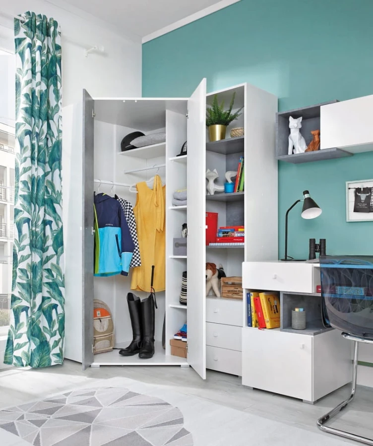 Großer weißer Eckschrank im hellen Jugendzimmer mit integriertem Regalsystem und Kleiderstange.