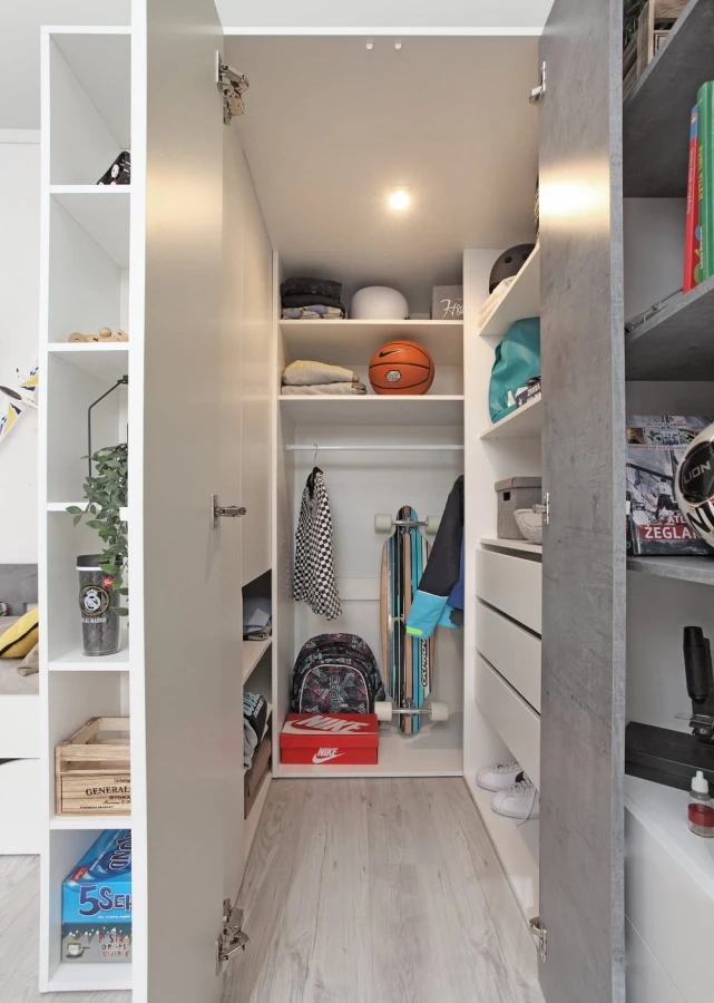 Begehbarer Kleiderschrank Innenansicht mit Regalsystem für Kleidung und Sportzubehör.