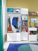 Modernes Kinderzimmer mit weißem Kleiderschrank, Regalsystem und blauem Teppich.