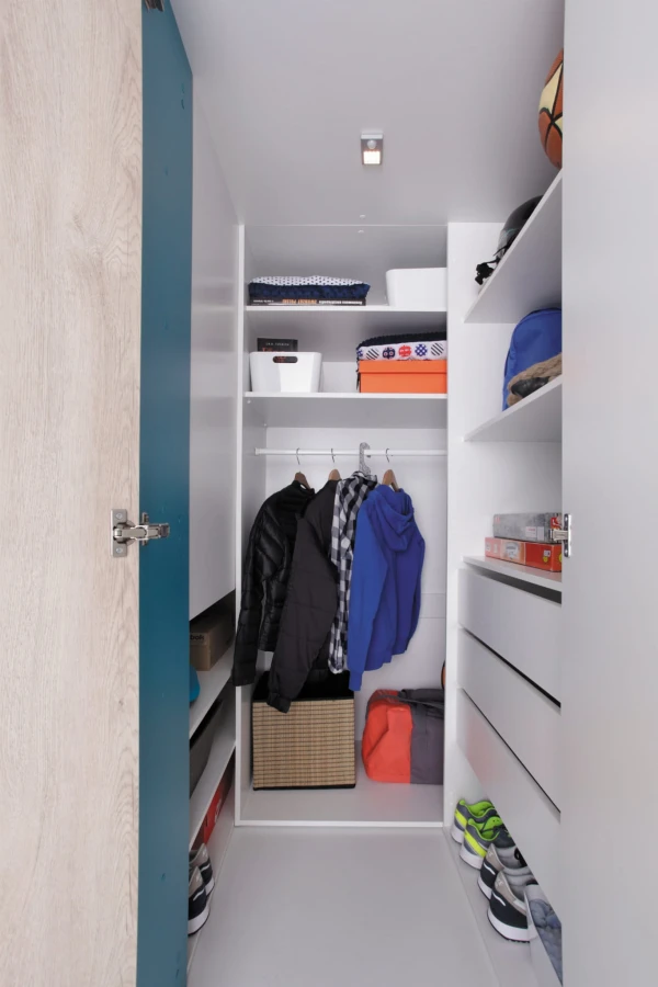 Einblick in einen gut organisierten begehbaren Kleiderschrank in Weiß und Blau.