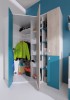 Begehbarer Eckkleiderschrank in Blau und Weiß mit Kleiderstange und Regalen für das Jugendzimmer.