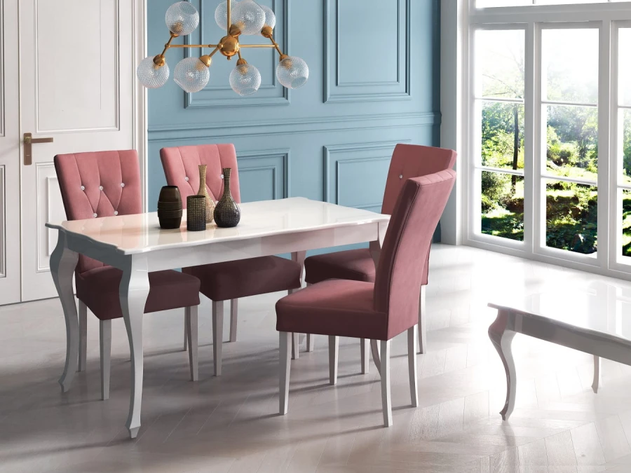 Stilvolles Esszimmer-Set: Weißer Tisch mit vier rosa Samtstühlen vor einer blauen Wand.