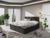 Anthrazitfarbenes Boxspringbett mit weißer Bettwäsche in modernem Ambiente.