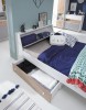 Weißes Kinderbett mit praktischem Bettkasten in Holzoptik und aufklappbarem Stauraum-Kopfteil.