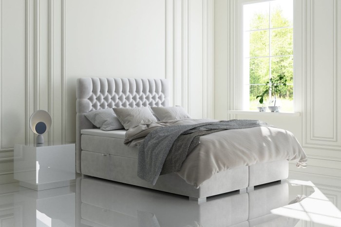 Modernes hellgraues Boxspringbett mit gestepptem Kopfteil in weißem Schlafzimmer