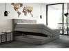 Graues Boxspringbett mit geöffnetem Bettkasten und Stauraum im modernen Schlafzimmer.