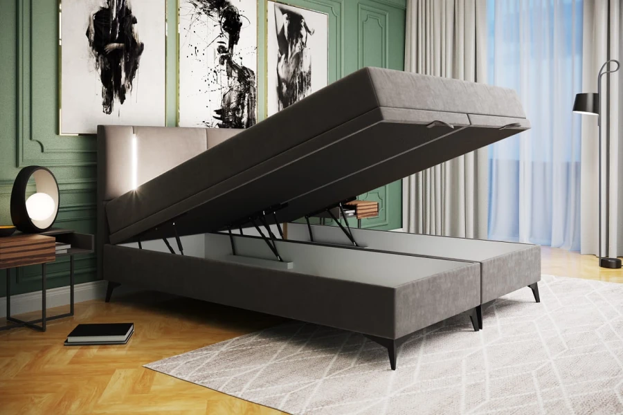 Graues Boxspringbett mit praktischem, seitlich aufklappbarem Bettkasten.