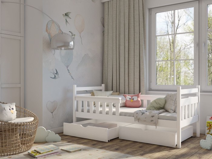 Weißes Kinderbett aus Massivholz mit praktischen Schubfächern im hellen Kinderzimmer.