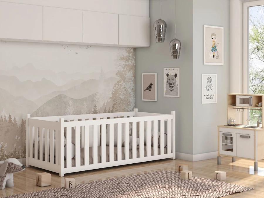 Weißes Babybett aus Holz in einem hell eingerichteten Kinderzimmer.