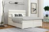 Weißes Boxspringbett im modernen Schlafzimmer mit stilvoller Dekoration und Teppich.