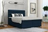 Blaues Boxspringbett in modernem Schlafzimmer mit Bettkasten und gepolstertem Kopfteil.