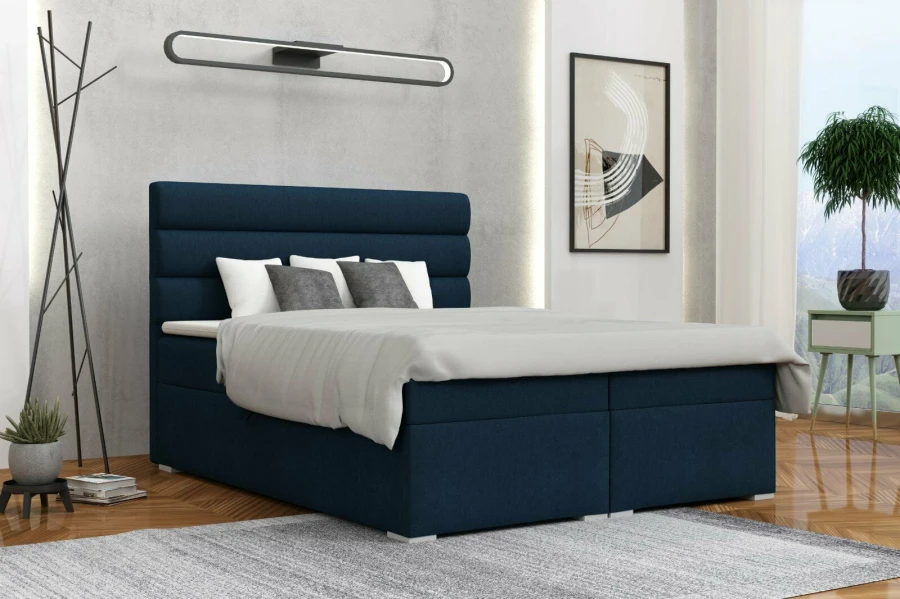 Blaues Boxspringbett in modernem Schlafzimmer mit Bettkasten und gepolstertem Kopfteil.