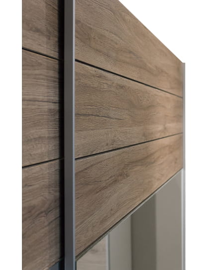 Detailansicht der rustikalen Holzoberfläche und Griffleiste am Schwebetürenschrank.