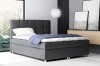 Elegantes dunkelgraues Boxspringbett mit dekorativem Kopfende.