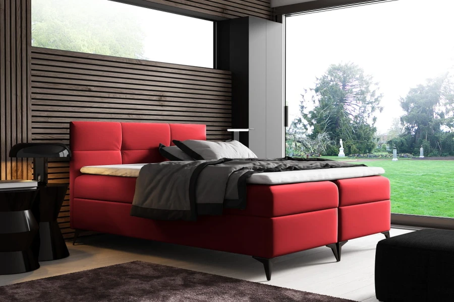 Rotes Boxspringbett in modernem Design vor einer Lamellenwand aus Holz.