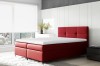 Elegantes rotes Boxspringbett im modernen Schlafzimmer-Ambiente mit Fensterfront.