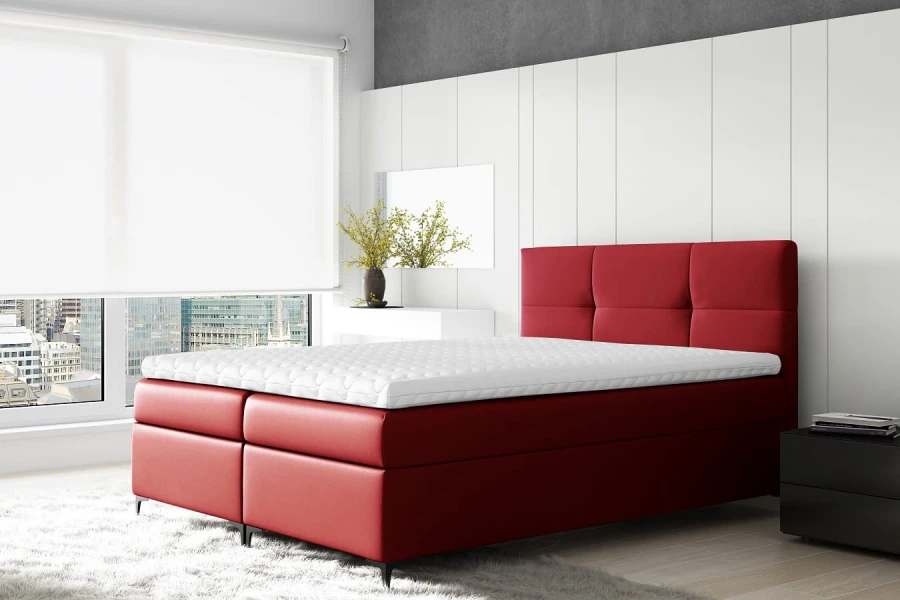 Elegantes rotes Boxspringbett im modernen Schlafzimmer-Ambiente mit Fensterfront.