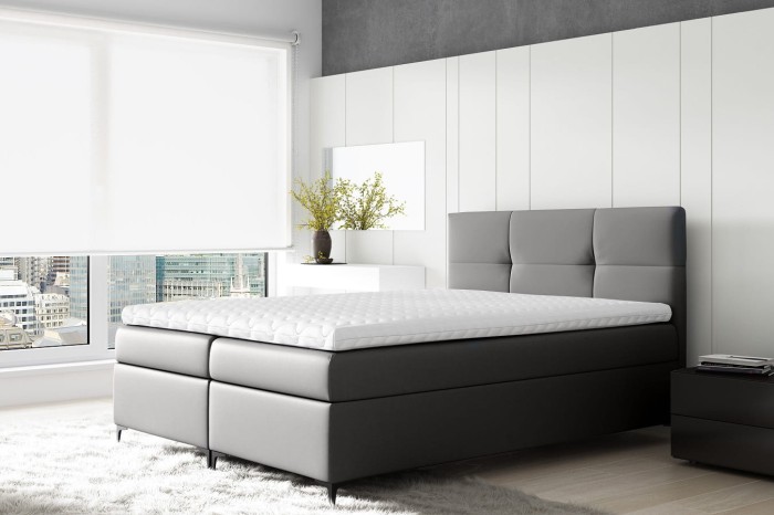 Graues Boxspringbett mit gestepptem Kopfteil in modernem, minimalistischem Schlafzimmer.