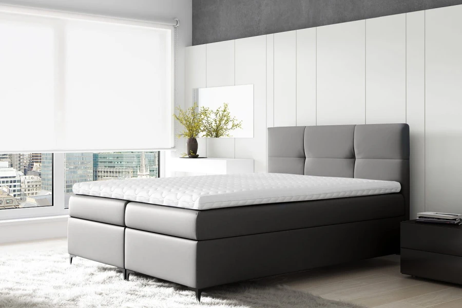 Graues Boxspringbett mit gestepptem Kopfteil in modernem, minimalistischem Schlafzimmer.
