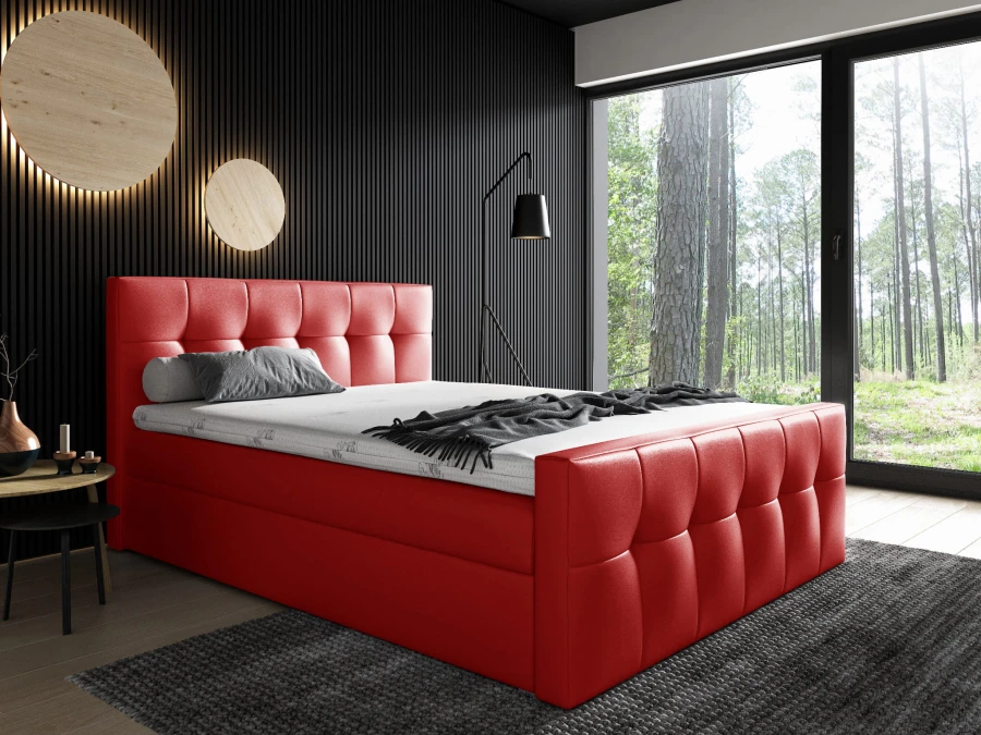 Auffälliges rotes Polsterbett mit gestepptem Design vor einer dunklen Wand.