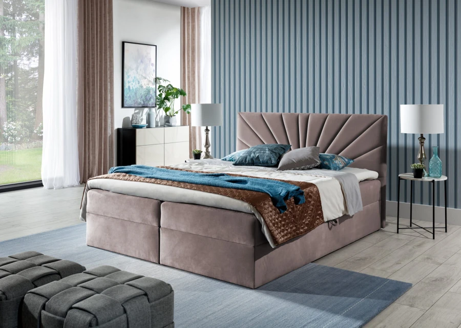 Rosa Boxspringbett mit fächerförmigem Kopfteil vor einer blau gestreiften Wand.