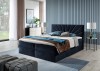 Dunkelblaues Boxspringbett mit fächerartiger Steppung im Schlafzimmer-Ambiente.