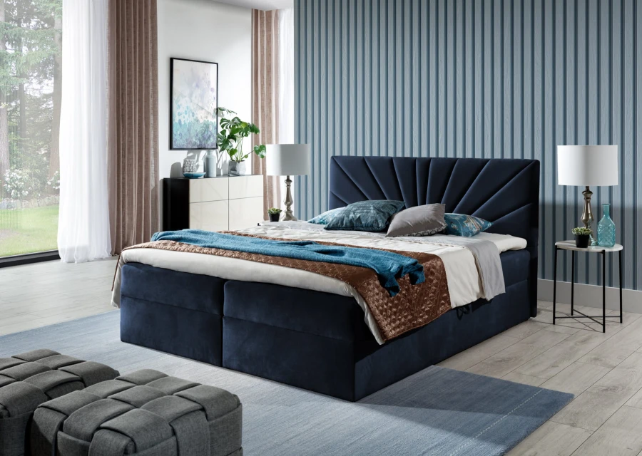 Dunkelblaues Boxspringbett mit fächerartiger Steppung im Schlafzimmer-Ambiente.