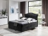 Schwarzes Boxspringbett mit hohem, gepolstertem Kopfteil und modernem Design für das Schlafzimmer.