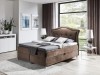 Braunes Boxspringbett mit gepolstertem Kopfteil in modernem Schlafzimmer.