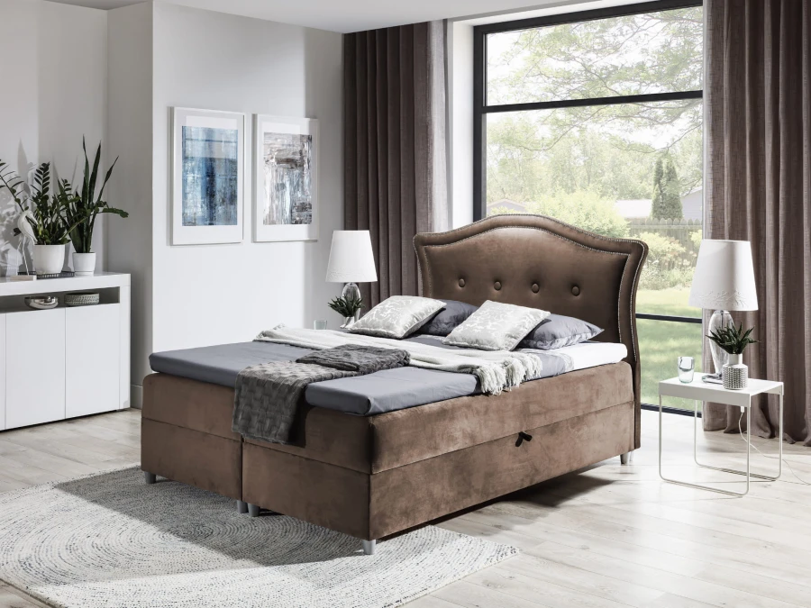 Braunes Boxspringbett mit gepolstertem Kopfteil in modernem Schlafzimmer.