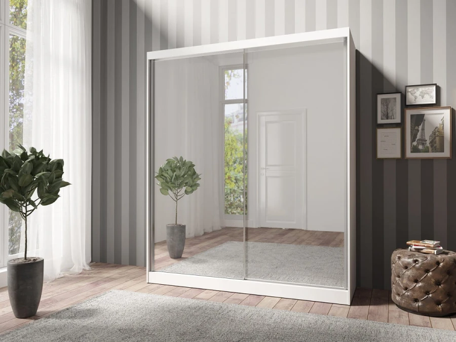 Geschlossener weißer Kleiderschrank mit zwei großen Spiegelfronten und Schwebetüren in moderner Schlafzimmer-Umgebung.