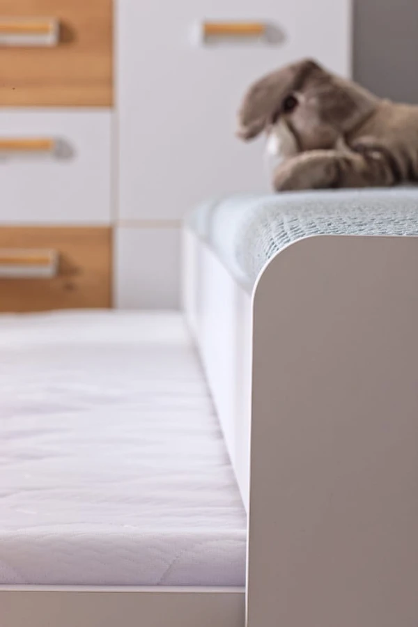 Platzsparendes weißes Funktionsbett mit integriertem Ausziehbett für Gäste.