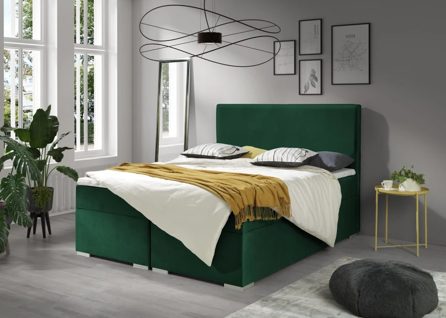 Grünes Boxspringbett aus Samt in einem modernen, hellen Schlafzimmer-Ambiente.