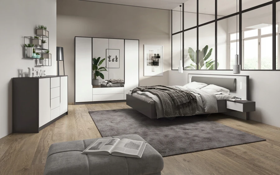 Modern bedroom set including bed, large wardrobe and chest of drawers.