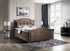 Elegantes braunes Bett mit geschwungenem Kopfteil und Knopfheftung für Schlafzimmer.