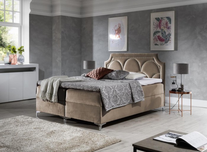 Elegantes Boxspringbett in Beige mit dekorativem Kopfteil im Schlafzimmer.