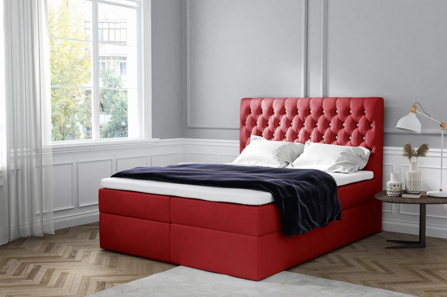 Elegantes rotes Boxspringbett mit gepolstertem Kopfteil im modernen Design.