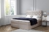 Beiges Boxspringbett mit gepolstertem Chesterfield-Kopfteil und Topper im Schlafzimmer.
