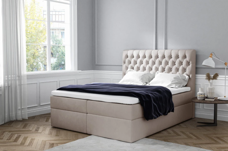 Beiges Boxspringbett mit gepolstertem Chesterfield-Kopfteil und Topper im Schlafzimmer.