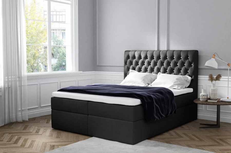 Schwarzes Boxspringbett mit dekorativer Steppung am Kopfteil für modernes Wohnen.