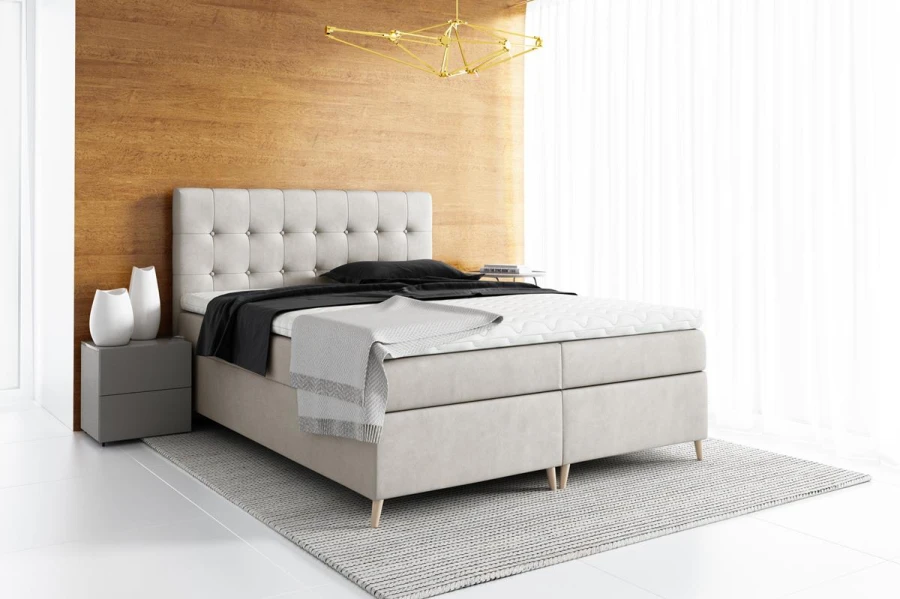 Beiges Boxspringbett mit Knopfsteppung im modernen Schlafzimmer-Ambiente.