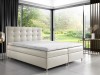 Modernes Boxspringbett in Beige mit gestepptem Kopfteil und Blick ins Grüne.
