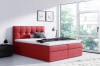 Rotes Boxspringbett mit Karosteppung am Kopfteil und gemütlichen Kissen im Schlafzimmer.