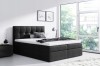 Schwarzes Boxspringbett mit Polster-Kopfteil und weißer Matratze in eleganter Einrichtung.