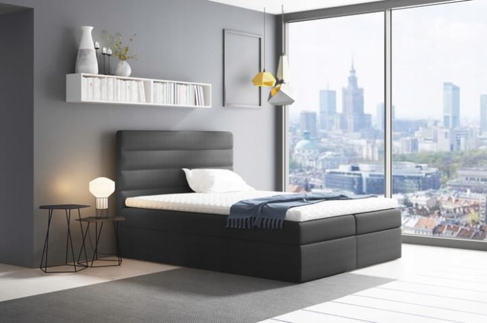 Anthrazitfarbenes Boxspringbett in modernem Schlafzimmer mit Ausblick auf die Stadt.
