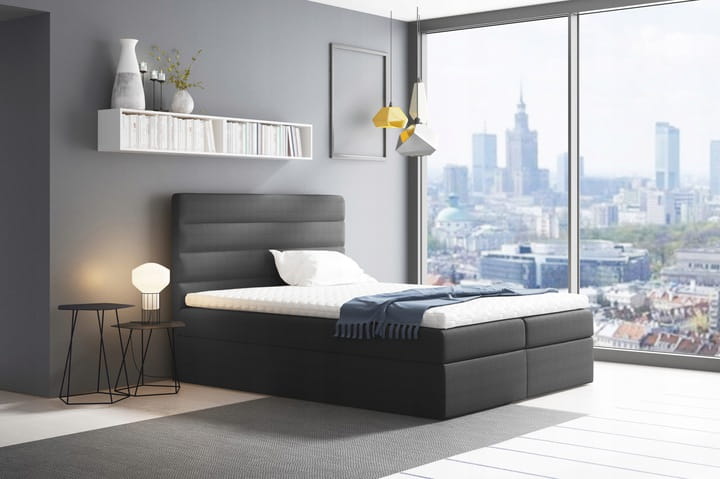 Anthrazitfarbenes Boxspringbett in modernem Schlafzimmer mit Ausblick auf die Stadt.