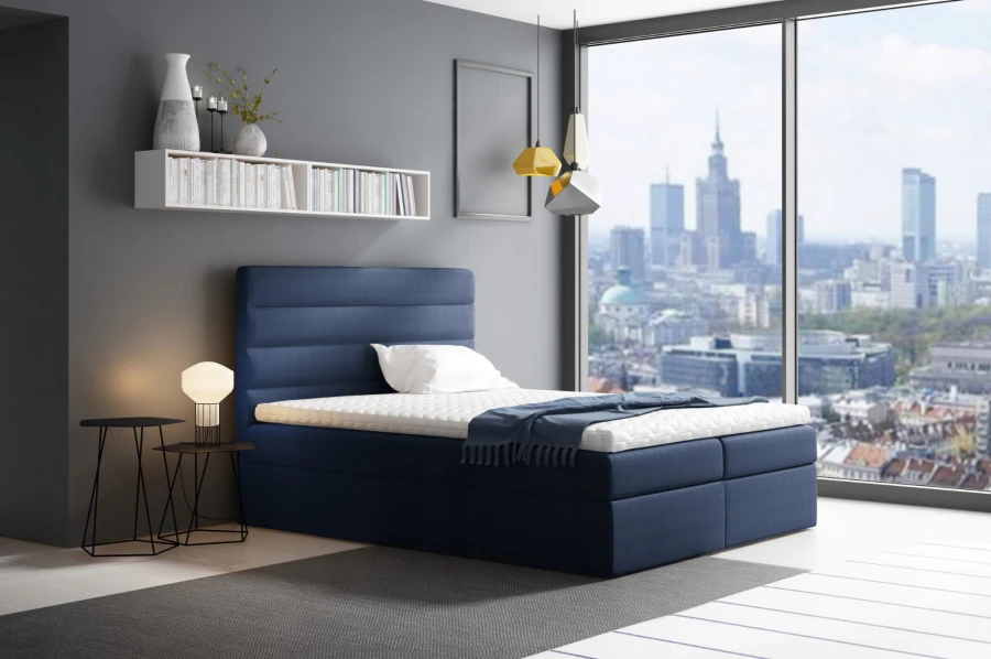 Dunkelblaues Boxspringbett in modernem Zimmer mit Panorama-Stadtblick und Design-Lampe.