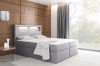 Graues Boxspringbett mit LED-Beleuchtung im Kopfteil, modernes Schlafzimmer mit Holzoptik-Wand.