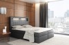 Anthrazitfarbenes Boxspringbett mit LED-Kopfteil und moderner Stadtansicht im Hintergrund.