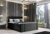 Modernes schwarzes Polsterbett in elegantem Schlafzimmer mit Blick in den Wald.